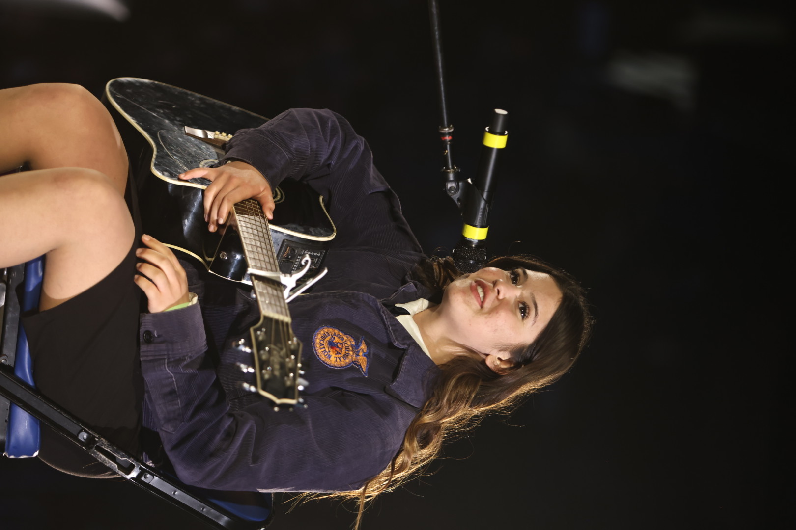 Talent finalists sits and plays her guitar